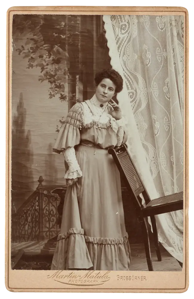 Frau, vor einem Vorhang stehend